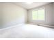 This is a simple carpeted bedroom with natural light coming through a large window at 3500 Millwater Xing, Dacula, GA 30019