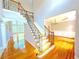 Elegant foyer with hardwood floors, staircase featuring decorative railings, and an open view to the dining room at 3500 Millwater Xing, Dacula, GA 30019