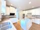 This is a well-lit kitchen featuring white cabinets, granite countertops, stainless steel appliances, and hardwood floors at 3500 Millwater Xing, Dacula, GA 30019