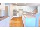 This is a bright and spacious kitchen featuring white cabinets, hardwood floors, and stainless steel appliances at 3500 Millwater Xing, Dacula, GA 30019