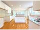 This is a well-lit kitchen with white cabinets, hardwood floors, granite countertops, and stainless steel appliances at 3500 Millwater Xing, Dacula, GA 30019