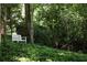 Secluded backyard retreat with a white bench nestled among lush greenery and mature trees at 4705 Paran Nw Vly, Atlanta, GA 30327