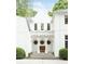 Elegant white stucco home featuring a covered entryway with decorative columns and arched windows at 4705 Paran Nw Vly, Atlanta, GA 30327