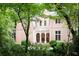 Stunning pink home with a beautiful white column-lined porch and landscaped greenery around the front at 4705 Paran Nw Vly, Atlanta, GA 30327