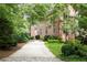 Charming pink home featuring a lush green yard and a long driveway leading to the entrance at 4705 Paran Nw Vly, Atlanta, GA 30327