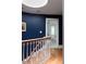 Hallway view with stairs, wooden railing, and a bedroom at the end of the hall at 4705 Paran Nw Vly, Atlanta, GA 30327
