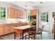 Well-lit kitchen featuring wood cabinets, tiled floors, and a door leading to the backyard at 4705 Paran Nw Vly, Atlanta, GA 30327