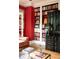 Living room features a red accent wall, bookshelves, and a black antique cabinet at 4705 Paran Nw Vly, Atlanta, GA 30327