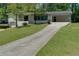 Exterior of a white home showcasing the long driveway leading up to a carport, surrounded by a green lawn at 1987 Darrell Dr, Marietta, GA 30066