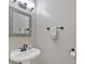 Modern bathroom features a gray-framed mirror, a pedestal sink, and updated fixtures at 261 Venture Path, Hiram, GA 30141