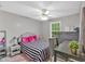 Charming bedroom with stylish striped bedding, neutral walls, and a ceiling fan at 261 Venture Path, Hiram, GA 30141
