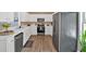 Bright kitchen featuring white cabinets and stainless steel appliances against wood floors at 261 Venture Path, Hiram, GA 30141