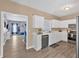 The kitchen features white cabinets, modern appliances, and seamlessly connected living spaces at 261 Venture Path, Hiram, GA 30141