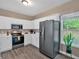 Bright kitchen featuring a stainless steel refrigerator, white cabinets, and natural light at 261 Venture Path, Hiram, GA 30141