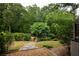 Spacious backyard with a wooden bridge surrounded by mature trees and lush greenery at 331 Gordon Ne Ave, Atlanta, GA 30307