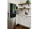 Well-lit kitchen with stainless steel refrigerator, white cabinetry, and open wooden shelving at 331 Gordon Ne Ave, Atlanta, GA 30307