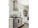 Gourmet kitchen featuring modern stainless steel range, bright white subway tile, and open wood shelves at 331 Gordon Ne Ave, Atlanta, GA 30307
