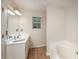 White bathroom features a soaking tub, clean vanity and a window with a view at 332 Red Fox Dr, Canton, GA 30114