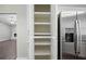 Spacious pantry with adjustable shelves and stainless steel refrigerator for organized storage solutions at 2035 Mountain Rd, Cumming, GA 30040