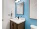 Stylish bathroom featuring a wooden vanity, white countertop, and a square mirror over a black faucet at 376 Eagle Tiff Dr, Sugar Hill, GA 30518