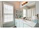 Bathroom with double sink vanity, decorative light fixture, and a shower at 376 Eagle Tiff Dr, Sugar Hill, GA 30518