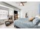 Bright bedroom features a ceiling fan, plush bedding, and bay window seating area at 376 Eagle Tiff Dr, Sugar Hill, GA 30518