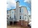 Exterior view of the home's siding, brick foundation, chimney, and rear wooden deck at 376 Eagle Tiff Dr, Sugar Hill, GA 30518