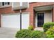 Townhome showcasing a two-car garage, front door, and manicured landscaping at 376 Eagle Tiff Dr, Sugar Hill, GA 30518