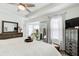 Bright main bedroom with hardwood floors, a large dresser, a ceiling fan, and a mirror at 376 Eagle Tiff Dr, Sugar Hill, GA 30518