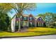 Brick house with black shutters, manicured lawn, and mature trees at 4015 Dodds Grove Ln, Alpharetta, GA 30009