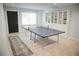 Finished basement with a ping pong table and wall shelving for storage at 4015 Dodds Grove Ln, Alpharetta, GA 30009
