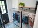 Laundry room with stainless steel washer and dryer on a patterned floor at 4015 Dodds Grove Ln, Alpharetta, GA 30009