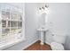 Bright powder room features a pedestal sink and large window at 5589 Trace Views Dr, Norcross, GA 30071