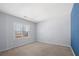 An empty bedroom with a window, carpet floors and blue accent wall at 5589 Trace Views Dr, Norcross, GA 30071