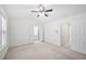 Bright and airy bedroom with neutral carpet, ceiling fan, and access to the bathroom and additional closets at 5589 Trace Views Dr, Norcross, GA 30071