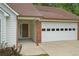 Close up of the home's entrance and garage with brick accents and fresh landscaping at 1095 Athena Ct, Acworth, GA 30101