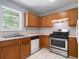 Functional kitchen with stainless steel range and oven, tile floor, and wood cabinets at 1095 Athena Ct, Acworth, GA 30101