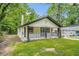 Charming home with a covered front porch and well-manicured lawn, perfect for enjoying the outdoors at 1477 Olive Sw St, Atlanta, GA 30310
