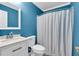 A full bathroom with blue walls, a sink and vanity, toilet, and bathtub at 2539 Lakeside Dr, Villa Rica, GA 30180