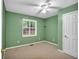This bedroom has neutral carpet, green walls, and a bright ceiling fan at 2539 Lakeside Dr, Villa Rica, GA 30180