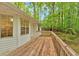 White home with wooden deck surrounded by lush green trees at 2539 Lakeside Dr, Villa Rica, GA 30180