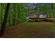 Rear exterior elevation of home with deck overlooking wooded landscape at 2539 Lakeside Dr, Villa Rica, GA 30180