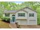 Charming two-story home with white siding, green shutters, and a two-car garage nestled amongst lush trees at 2539 Lakeside Dr, Villa Rica, GA 30180