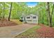 View of the home's exterior, featuring a large driveway and lush trees at 2539 Lakeside Dr, Villa Rica, GA 30180
