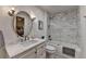 Stylish bathroom with a modern vanity, round mirror, and a shower-over-tub with marble tile surround at 5475 Trowbridge Dr, Dunwoody, GA 30338