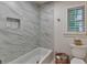 Elegant bathroom with a marble-tiled shower over tub, and a window with plantation shutters at 5475 Trowbridge Dr, Dunwoody, GA 30338