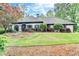 Beautiful one-story home with a manicured lawn and mature trees, showcasing its curb appeal at 5475 Trowbridge Dr, Dunwoody, GA 30338