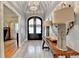 Grand foyer with a decorative chandelier, wood floors, and an elegant entry door at 5475 Trowbridge Dr, Dunwoody, GA 30338