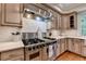 Gourmet kitchen boasts stainless steel appliances, marble backsplash, and custom cabinetry at 5475 Trowbridge Dr, Dunwoody, GA 30338