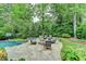 Backyard oasis featuring a large pool, spa, and stone patio with fire pit at 5475 Trowbridge Dr, Dunwoody, GA 30338